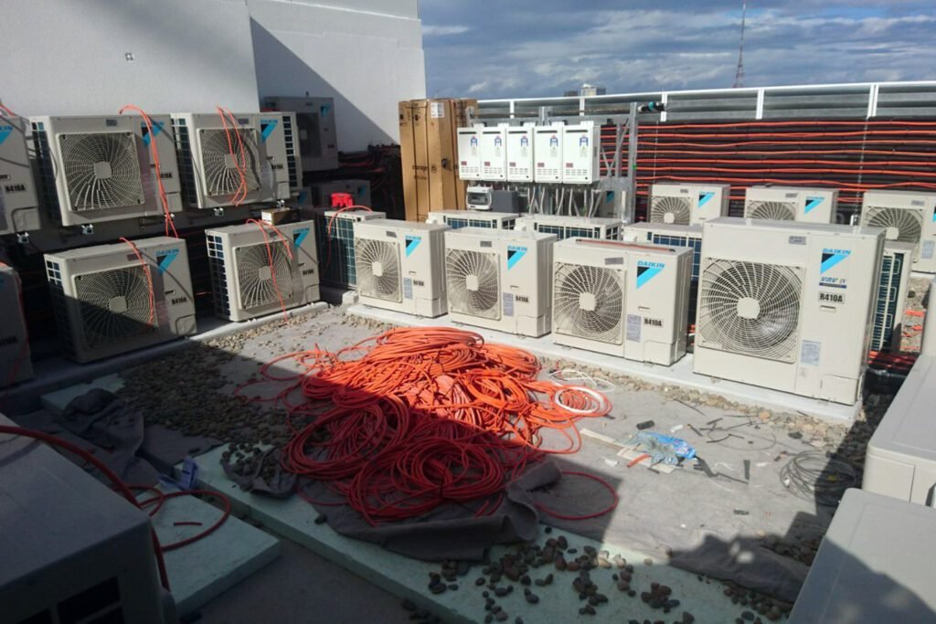 Outdoor VRF VRV air conditioning condensers with connected pipework on a commercial rooftop