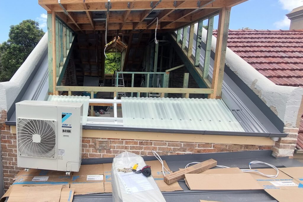 Technician installing a split system air conditioner outdoors for correct room size capacity
